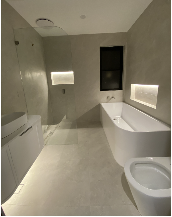 Modern bathroom with floating vanity underglow, illuminated shower niche and bathtub niche in warm LED light